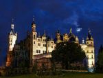 Photo by babaktafreshi  The first quarter moon shines through the clouds over the historic Schwerin...